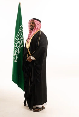 Saudi Man Holding Saudi Arabia Flag in Traditional Bisht