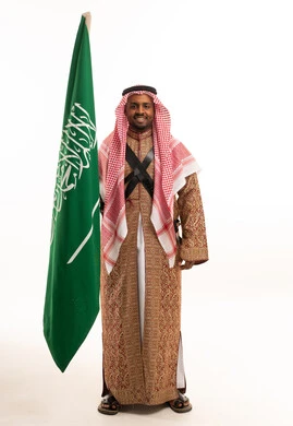 Saudi Man Holding National Flag in Traditional Attire