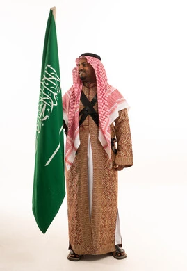 Saudi Man Holding National Flag in Traditional Ardah Dress