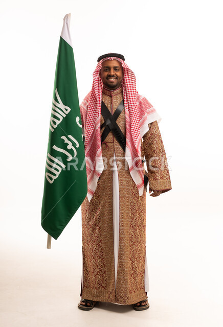 رجل سعودي يحمل العلم بالزي التراثي التقليدي
