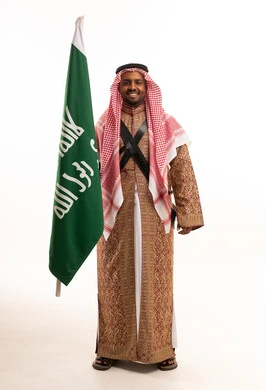 رجل سعودي يحمل العلم بالزي التراثي التقليدي