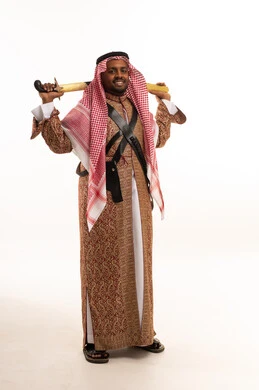 رجل سعودي بزي العرضة التقليدي يمسك السيف