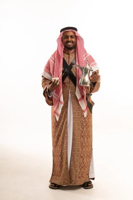 رجل سعودي بالزي التقليدي يحمل دلة قهوة عربية