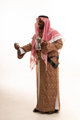 رجل سعودي بالزي الشعبي يحمل دلة القهوة العربية