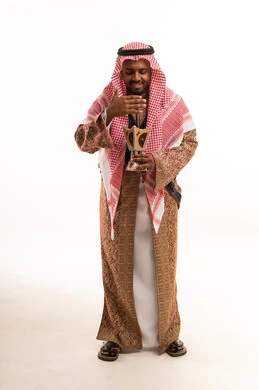 رجل سعودي بالزي التقليدي يحمل مبخرة بخور