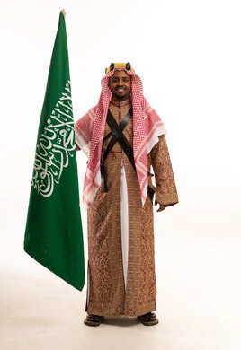Saudi Man in Traditional Ardah Dress Holding Saudi Flag