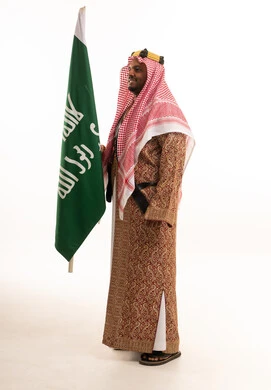Saudi Man in Traditional Ardah Costume Holding Flag