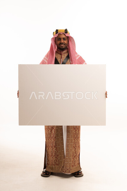 رجل سعودي بالزي التقليدي يحمل لوحة بيضاء فارغة
