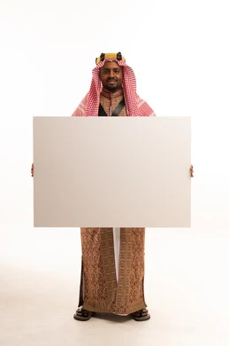 رجل سعودي بالزي التقليدي يحمل لوحة بيضاء فارغة