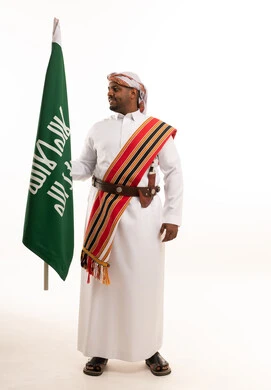 Saudi Man in Traditional Southern Dress Holding National Flag