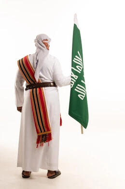 Saudi Man Holding National Flag in Traditional Attire