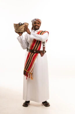 رجل عماني بالزي التقليدي يحمل سلة سعف