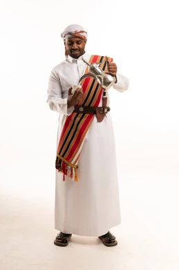 رجل سعودي بالزي التقليدي يصب القهوة العربية