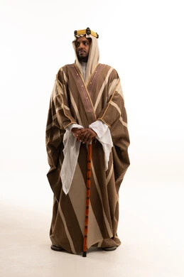 رجل سعودي بالفروة التقليدية البنية مع عصا خشبية