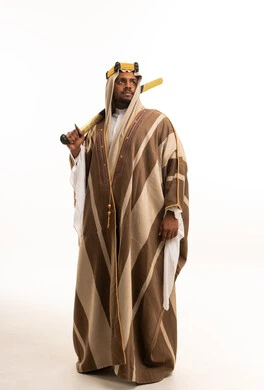 Saudi Man in Traditional Bisht Holding Sword Studio Shot