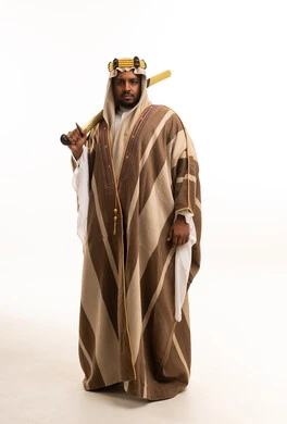 رجل سعودي يرتدي البشت التقليدي ويحمل سيفاً