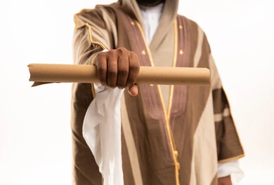 Saudi Man in Traditional Bisht Holding Rolled Document
