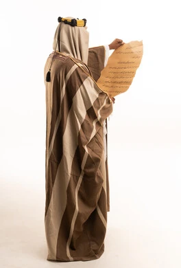 Saudi Man in Traditional Bisht Reading Arabic Manuscript
