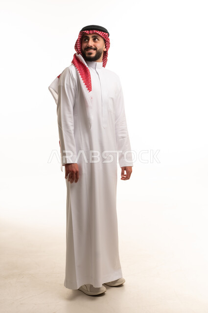 رجل سعودي يرتدي الزي التقليدي الثوب والشماغ على خلفية بيضاء
