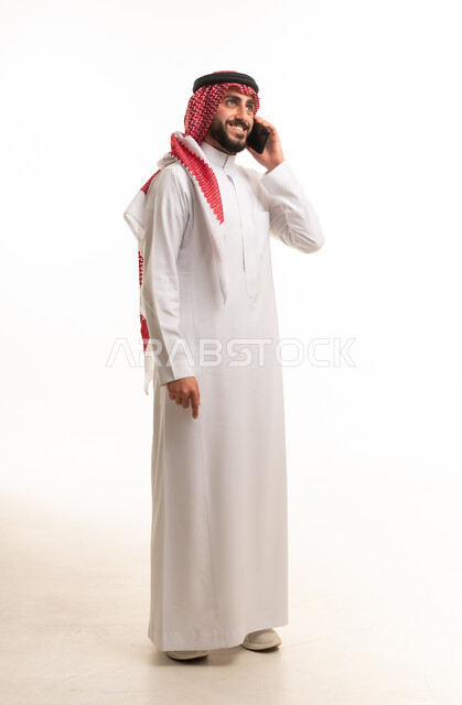 Saudi Man in Traditional Thobe Using Mobile Phone