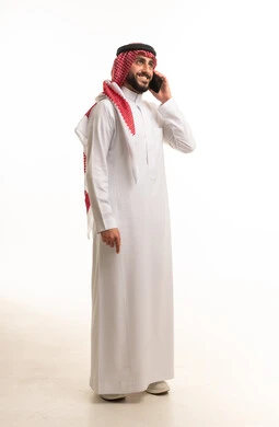 Saudi Man in Traditional Thobe Using Mobile Phone