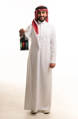 رجل سعودي يحمل فانوس رمضان التقليدي بخلفية بيضاء