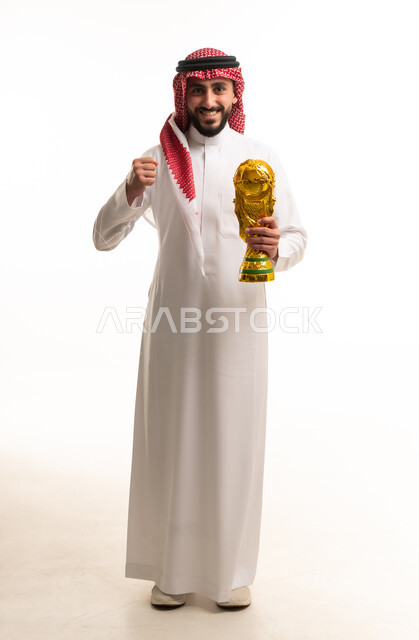رجل سعودي يحمل كأساً ذهبياً في الاستوديو