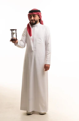 Saudi Man in Traditional Thobe Holding Hourglass