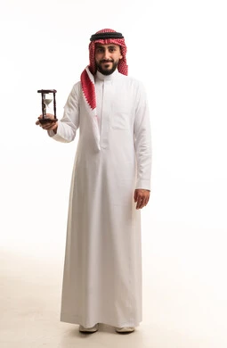 Saudi Man in Traditional Dress Holding Hourglass