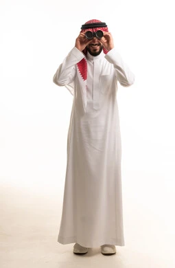 رجل سعودي بالزي التقليدي يستخدم المنظار