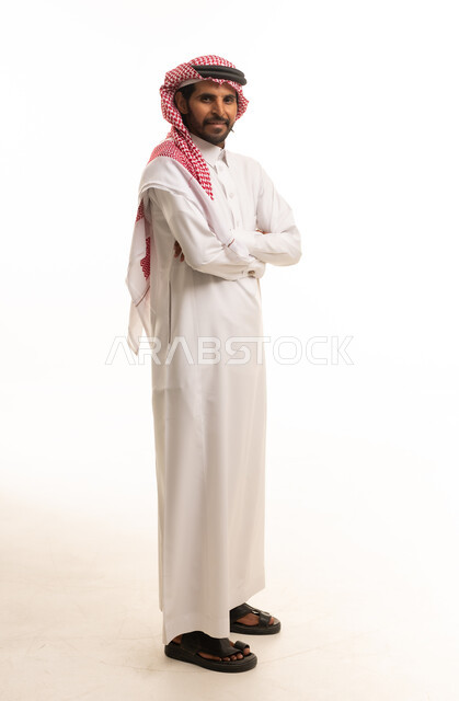 رجل سعودي يرتدي الثوب والشماغ التقليدي واقفاً