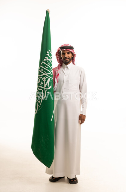 Saudi Man Holding Saudi Arabian Flag in Studio Portrait
