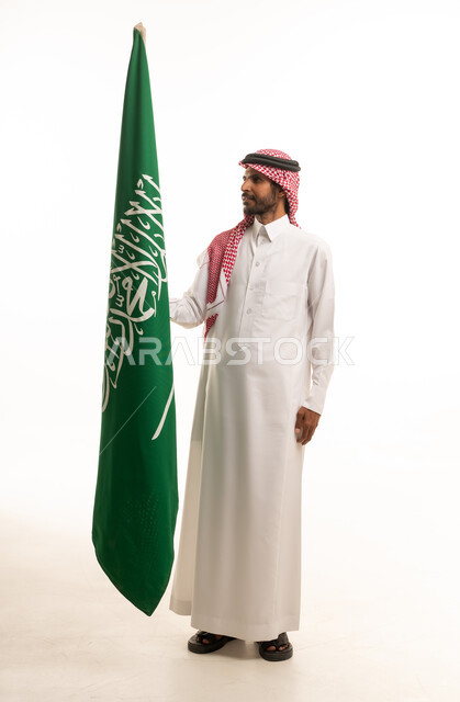 Saudi Man in Traditional Thobe Holding Saudi Arabia Flag