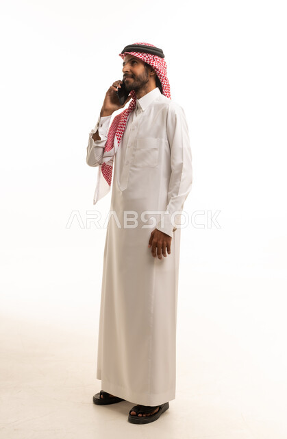 Saudi Man in Traditional Thobe Using Smartphone