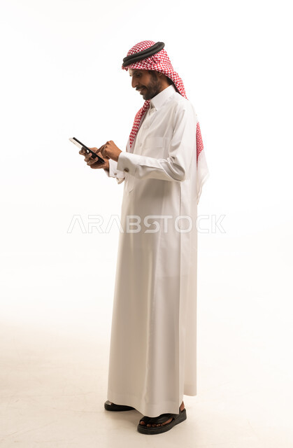 Saudi Man in Thobe Using Digital Tablet