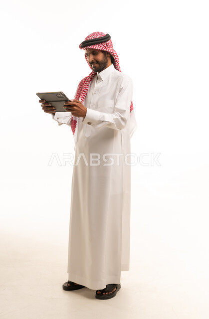 Saudi Man in Traditional Thobe Using Digital Tablet