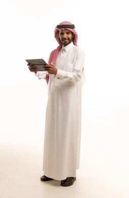 Saudi Man in Traditional Thobe Holding a Tablet