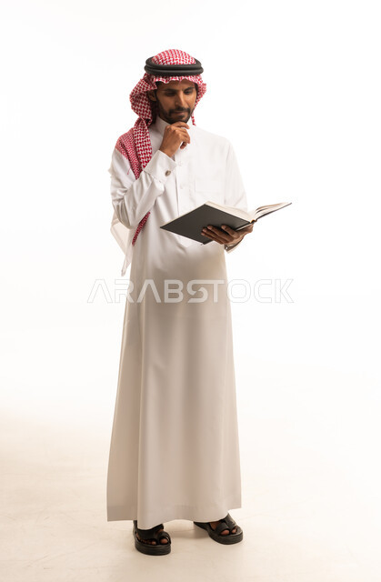 Saudi Man in Traditional Thobe Reading a Book