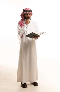 Saudi Man in Traditional Thobe Reading a Book