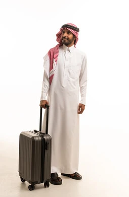 رجل سعودي بالزي التقليدي يحمل حقيبة سفر