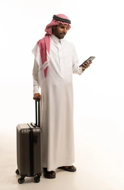 Saudi Man in Traditional Thobe with Suitcase and Phone