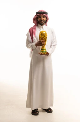 Saudi Man in Traditional Dress Holding Gold Football Trophy