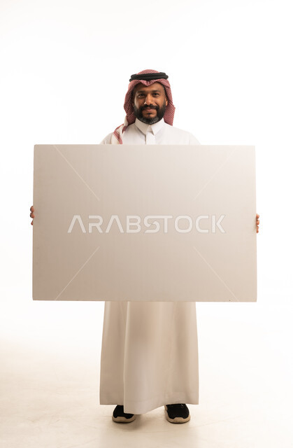 رجل سعودي يحمل لوحة بيضاء فارغة معزولة