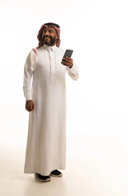 Smiling Saudi Man in Traditional Thobe Holding Smartphone