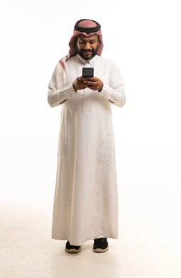 Saudi Man in Traditional Thobe Using Smartphone Full Body