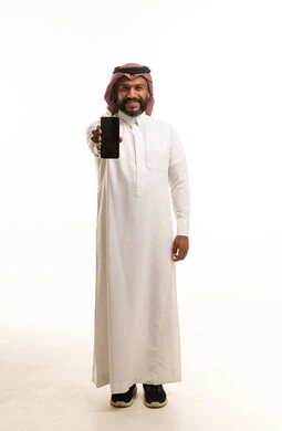 رجل سعودي يحمل هاتفا ذكيا بخلفية بيضاء