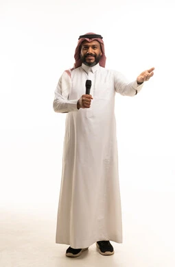 رجل سعودي يمسك ميكروفون على خلفية بيضاء