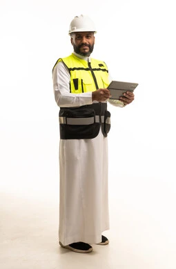 مهندس سعودي بمعدات السلامة يحمل جهاز لوحي رقمي