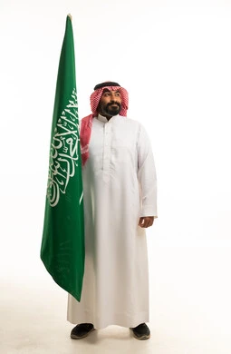 Saudi Man Holding Saudi Arabia Flag on White Background