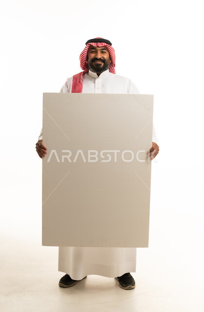 رجل عربي يحمل لوحة بيضاء فارغة في الاستوديو
